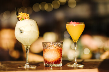 Variety of cocktails on bar counter under soft lighting