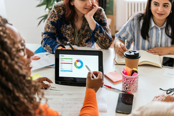 Diverse team analyzing budget in a coworking space using technology