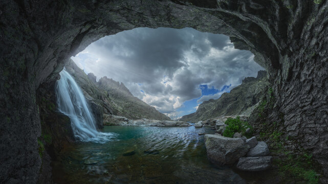 Tranquil waterfall viewed through a natural stone arch