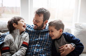 Laugh, hug and father with children on sofa for bonding, loving relationship and relax together in home. Family, happy and dad with young boys embrace for affection, care and love in living room