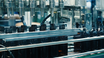 Bottles filling automation machine in modern factory. Technology demonstration of filling and...