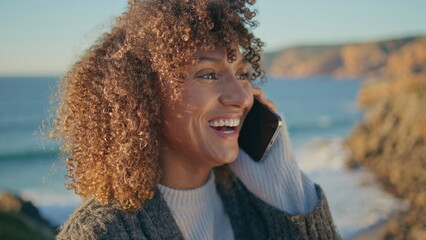 Laughing model smartphone call at sea background closeup. Excited woman talking