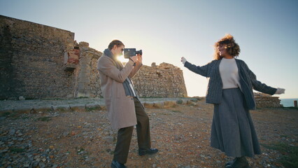 Photographer filming model evening beach. Joyful couple taking video at shore