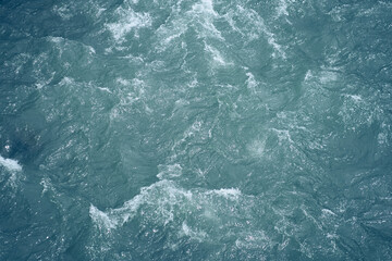 The water is uneven blue in color and a place to copy. Close-up of raging waters. Ripples and waves on the water. High quality photo