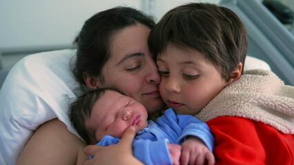 Mother embracing her two children a newborn and a big brother, highlighting the warmth of family love and connection in a hospital setting. themes of family bonds, maternal care, and sibling affection