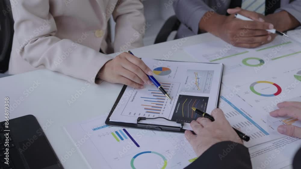 Wall mural Professionals discussing financial charts in a meeting, highlighting collaboration and data analysis in slow motion. Interactions and detailed examination of statistics