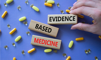Evidence Based Medicine symbol. Concept word Evidence Based Medicine on wooden blocks. Doctor health. Beautiful purple background with pills. Medicine and Evidence Based Medicine concept. Copy space