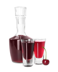 Bottle and shot glasses of delicious cherry liqueur isolated on white