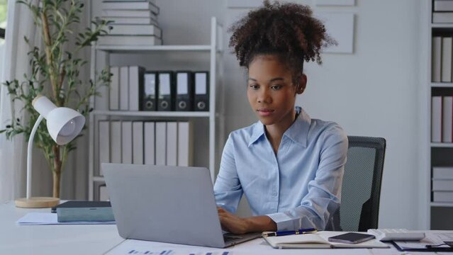 Professional woman sneezes at desk in modern office, reacting to cold symptoms. Health and productivity concept