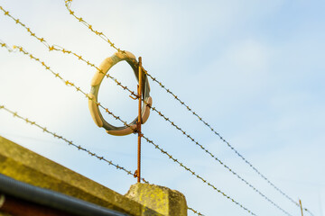 Obraz premium overlay for a car steering wheel hanging on barbed wire on a fence, symbolizing automotive customization, edginess, and unconventional design elements