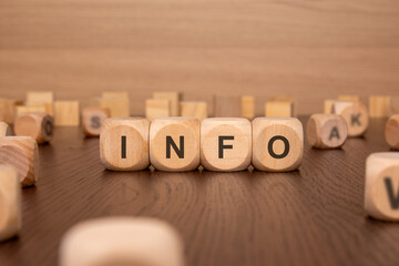 four wooden cubes with the text 'INFO' on a brown background