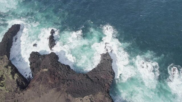 aerial drone shot drone going up and flying away from rocky coastline and rough sea in Azores Portugal