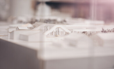 Architecture, building and model on desk in office for property, design or expansion for urban project. Prototype, structure and planning for construction, real estate or development for neighborhood