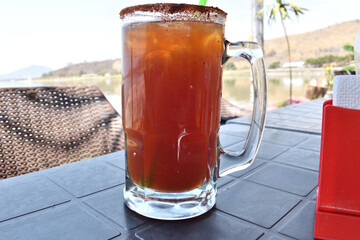 Horizontal view of a drink called michelada served in a beer mug in a restaurant, mexican