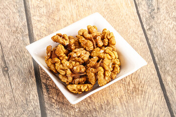 Cracked unshelled walnut in the bowl