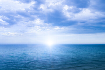 Obraz premium Calm windless ocean with the sun on the horizon.