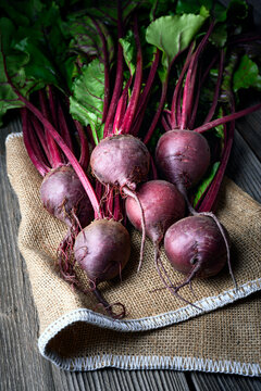 Bunch of fresh ripe beets with greens on a wooden table on sackcloth. Food photography