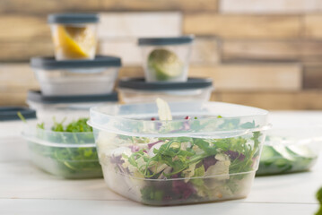 Chopped salad, vegetables and herbs in a plastic container. Storing food for freezing