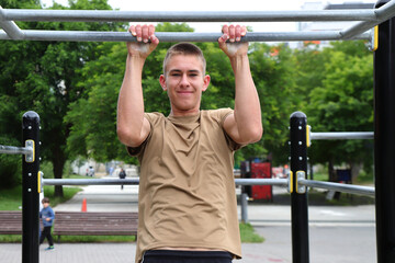 Teenager 16 years doing workout on horizontal bar, outdoor sport, young sportsman, healthy life...