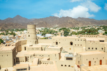 Bahla citadel fortress inner yard and round tower with town in the background, Bahla, Oman