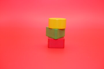 colorful wooden toys isolated red background. wooden toys shaped like triangles, squares and circles.
