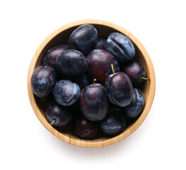 Bowl with ripe plums on white background