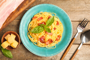 Plate with tasty pasta carbonara on wooden background