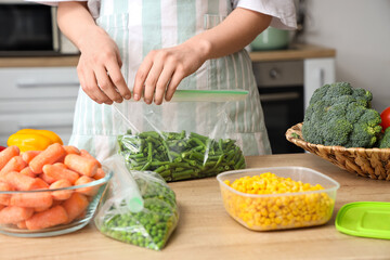Woman holding plastic bag with green beans for freezing in kitchen