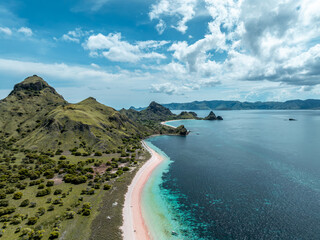 Obraz premium Aerial image of pink sand beach with long tail boats in tropical water on Padar Island, komodo national park, indonesia