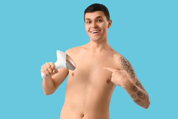 Fototapeta premium Young man with photoepilator on blue background