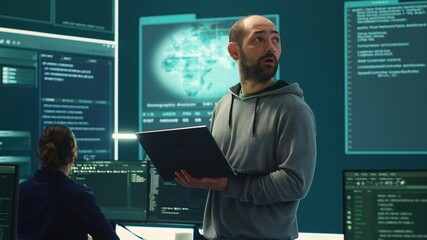 Governmental hackers breaching network security with advanced techniques, cyber defense in action. Team of IT experts working on gaining access to collect information, big screen. Camera A.