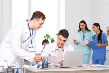 Male doctors working at table in clinic