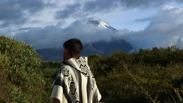 Young Latin in Poncho Observing Cotopaxi Volcano (5,897 m) Amid Clouds at Sunset