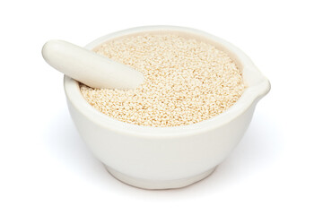 Close-up of Dry Organic White Sesame seeds (Sesamum indicum) or Til, in white ceramic mortar and pestle, isolated on a white background.