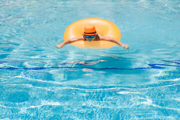 Child splashing in swimming pool. Active healthy lifestyle, swim water sport activity on summer vacation with child. Child water toys.