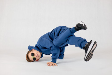 Little Boy in a dancing position. Kid model. A smiling boy on a white background.Portrait of a...