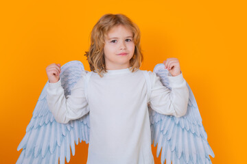 Kid wearing angel costume white dress and feather wings. Innocent child. Little angel on isolated...