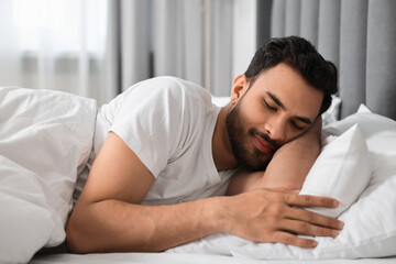 Handsome man sleeping in bed at morning