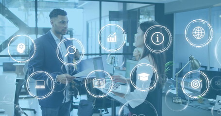 Image of icon in circles over diverse coworkers sharing ideas in office