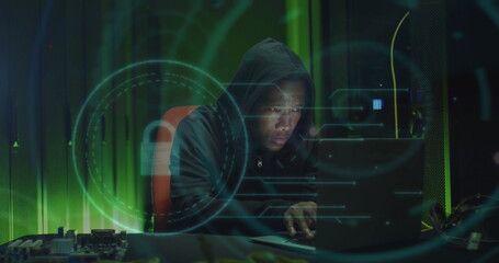 Image of padlock icon over african american male hacker using laptop