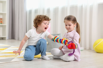 Cute little children playing with funny sock puppets in kindergarten