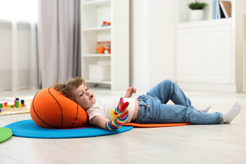 Cute little boy playing with funny sock puppet on floor in kindergarten