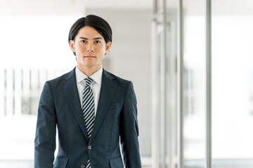 Fototapeta premium 会社・オフィスに出勤・出社・通勤する若い男性アジア人ビジネスマン 