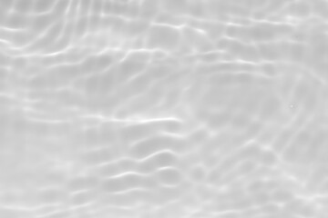 White water with ripples on the surface. Defocus blurred transparent white colored clear calm water surface texture with splashes and bubbles. Water waves with shining pattern texture background.