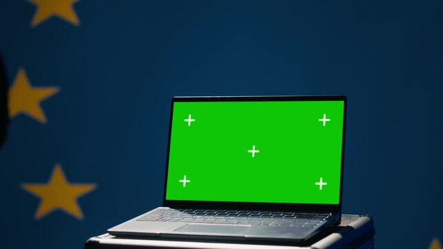 European Union agency using green screen laptop to protect against mass propaganda affecting elections. EU security service engaging in psychological operations using mockup device, close up, camera A