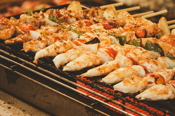 A grill full of skewers of meat and vegetables