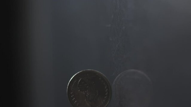One Swiss Franc coin rotating slow motion, 1 CHF, vertical view