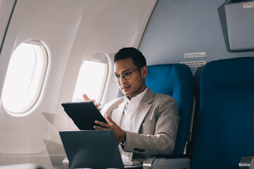 Airplane, travel and portrait of businessman working on laptop computer and smartphone while sitting in airplane.