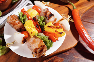 Barbecue grilled sliced ​​meat and vegetables on a wooden table