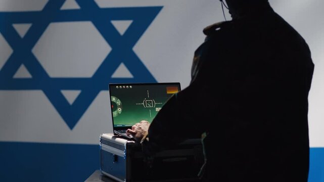 Israel Defense Forces dispatcher looking at surveillance transmission on laptop, relaying data to troops using headphones microphone, isolated over israeli flag background, camera A